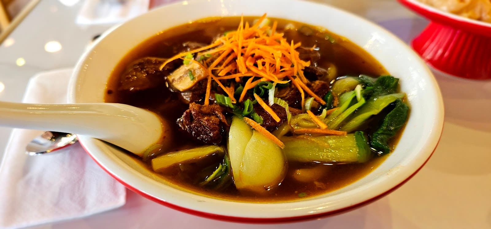 Nahaufnahme einer Rinder-Nudelsuppe mit Pak Choi und Karotte