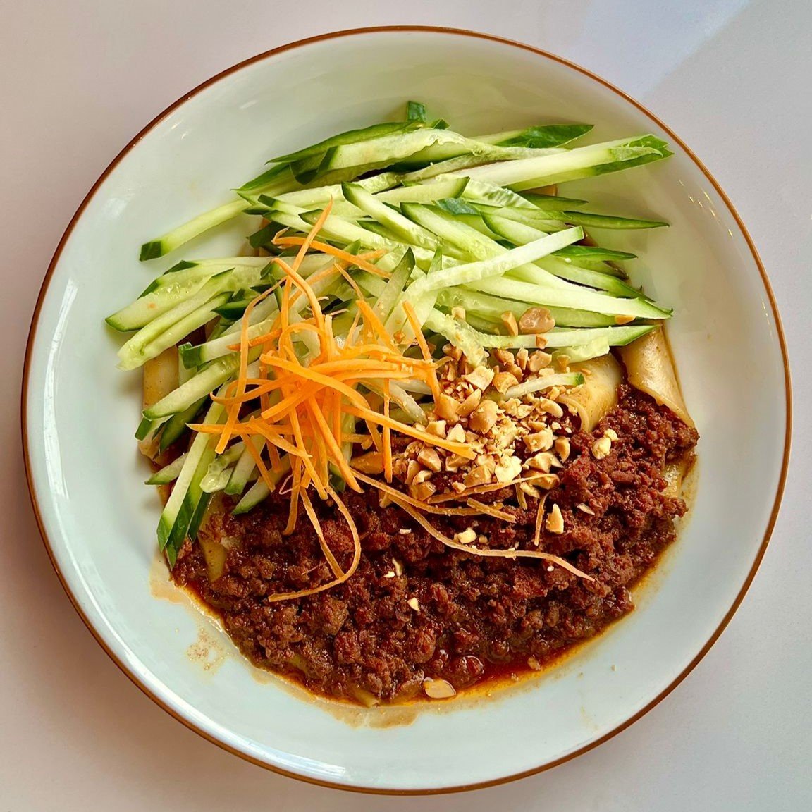 Kalter Nudelsalat mit Gurke, Karotte, würziger Hackfleischsauce und Erdnüssen